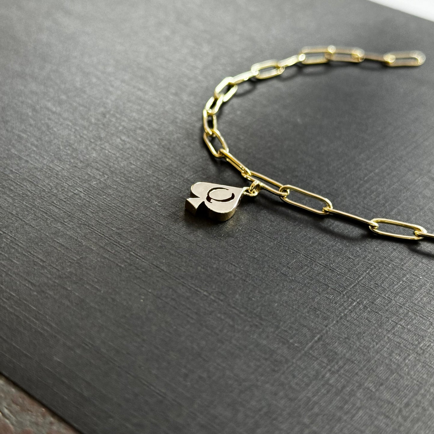 The QoS Charm in gold