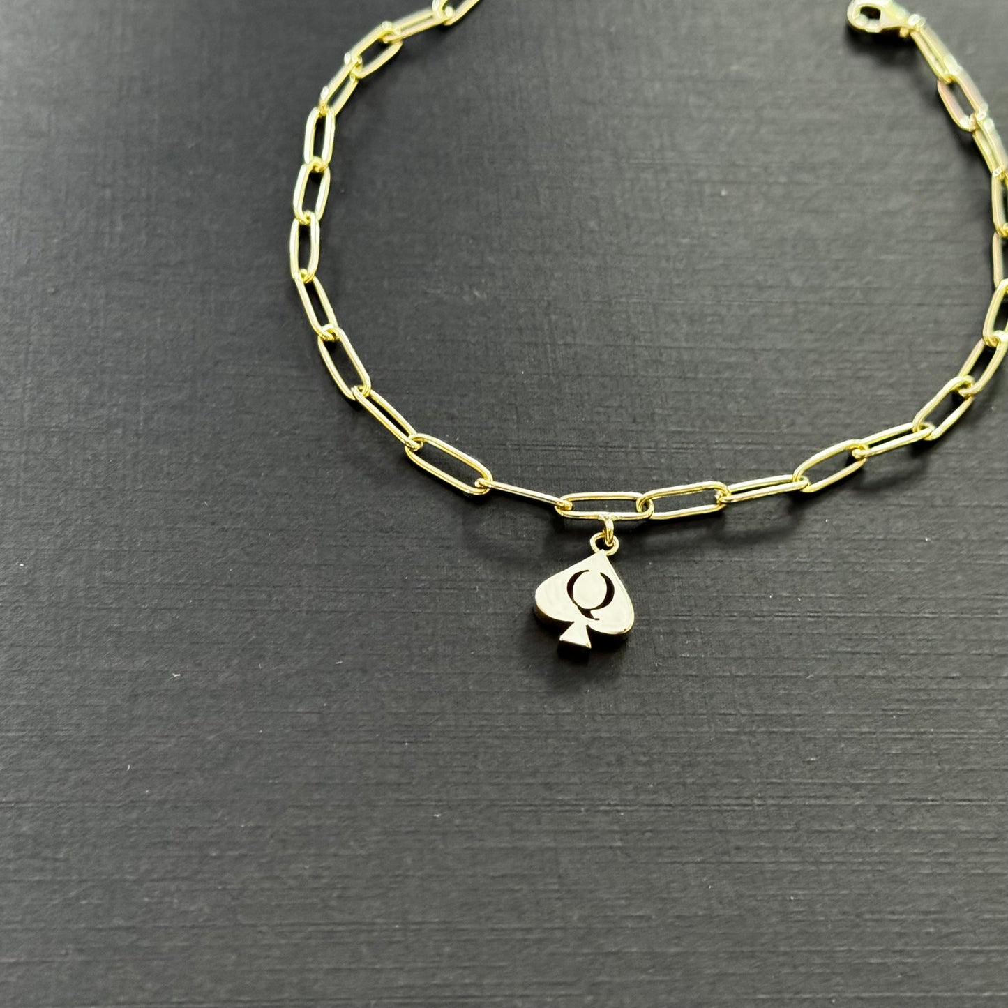 The QoS Charm in gold